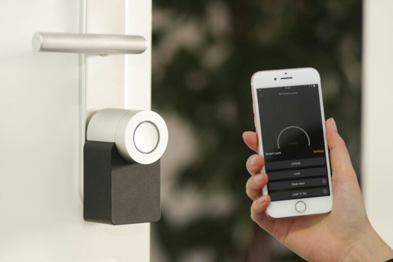 Person using a security app on a phone beside a smart door lock