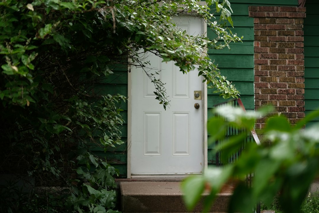 White front door framed by greenery, a typical spot for a video doorbell installation in Windsor